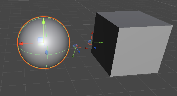 Сфера и куб в Unity Editor с масштабированными инструментами преобразования.